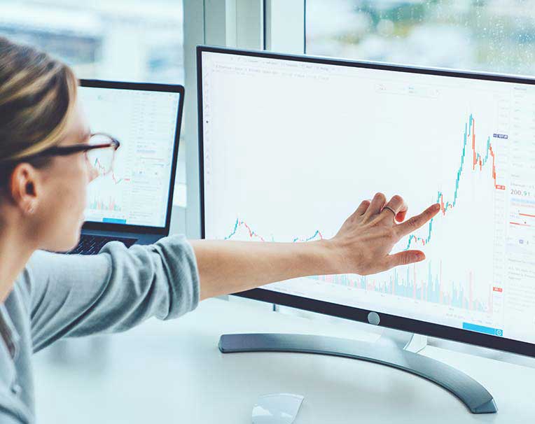 Business woman pointing at key statistic on computer screen